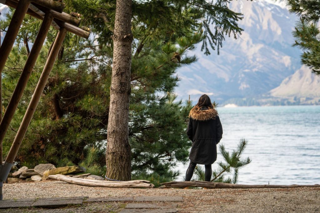 Woman in warm jacket overlooking Lake Hawea, South Island NZ